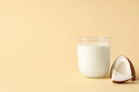 Glass of coconut milk on beige backgroundの写真素材