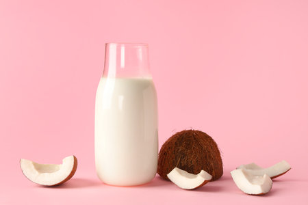 Glass bottle of coconut milk on pink backgroundの写真素材