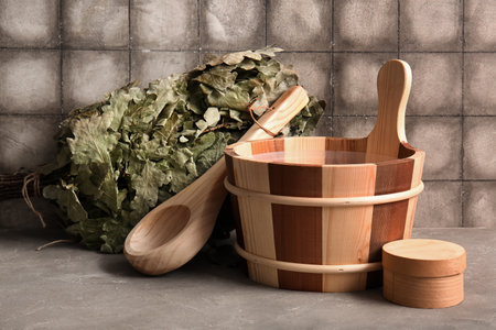 Set of accessories for sauna on table near grunge tile wallの写真素材
