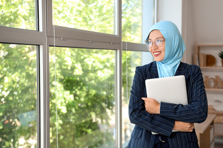 Young Muslim businesswoman with laptop at homeの写真素材