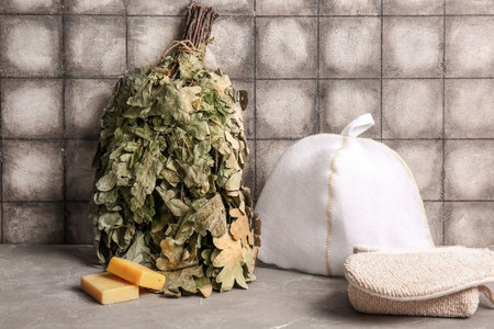 Set of accessories for sauna on table against grunge tile backgroundの写真素材