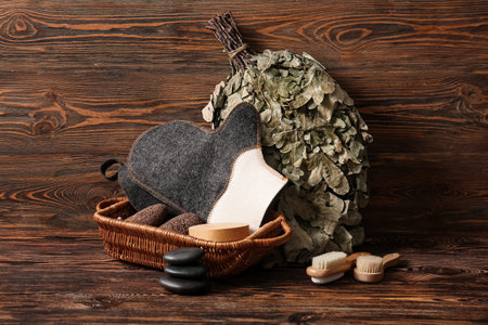 Set of accessories for sauna with oak broom on wooden background