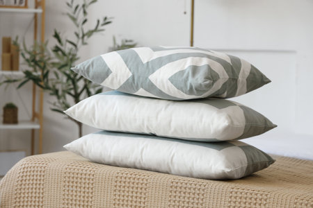 Stack of pillows on bed in light bedroom, closeupの写真素材