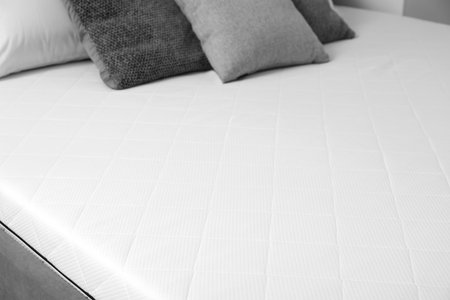 New orthopedic mattress on stylish bed in room, closeupの写真素材