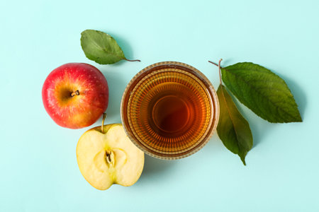 Glass of fresh apple juice on blue backgroundの写真素材