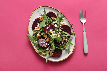 Plate of fresh salad with beet and cottage cheese on pink backgroundの写真素材