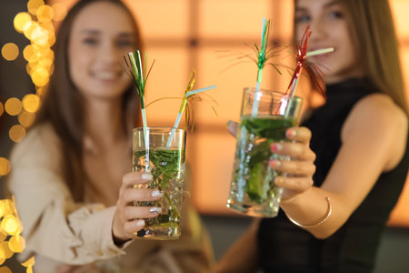 Beautiful young happy women with glasses of mojito in barの写真素材