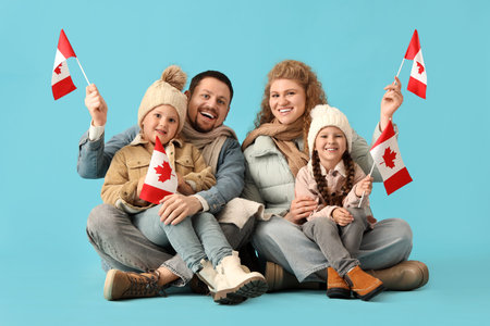 Happy beautiful family with flags of Canada sitting on blue background