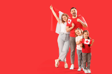 Happy family with flags of Canada against red backgroundの写真素材