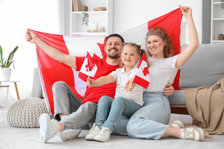 Happy family with flags of Canada sitting on floor at homeの写真素材