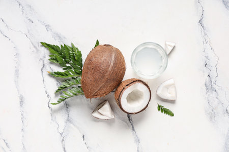 Fresh coconuts with glass of water and leaves on white backgroundの写真素材