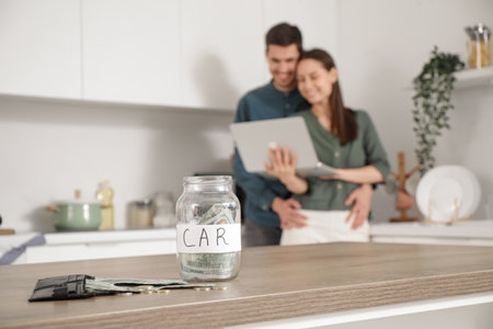 Jar with money for car of young couple in kitchen, closeupの写真素材