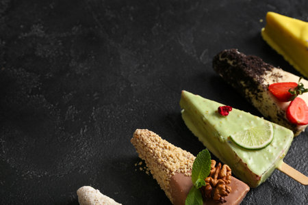 Tasty cheesecake pops on black background with space for text