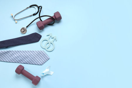 Tie, stethoscope, dumbbells, male sign and light blue ribbon on color background. Prostate cancer awarenessの写真素材