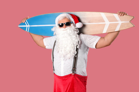 Santa Claus with surfboard on pink background. Christmas in Julyの写真素材