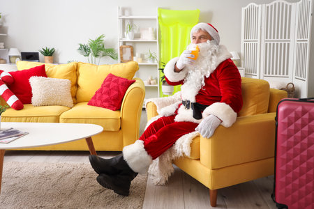 Santa Claus sitting on armchair at home. Christmas in Julyの写真素材