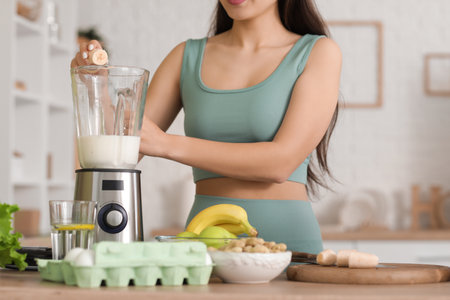 Sporty young Asian woman making protein shake at home, closeupの写真素材