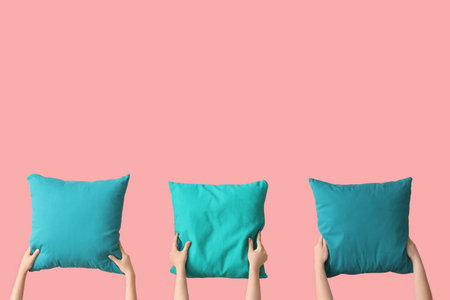 Women with bright blue pillows on pink backgroundの写真素材