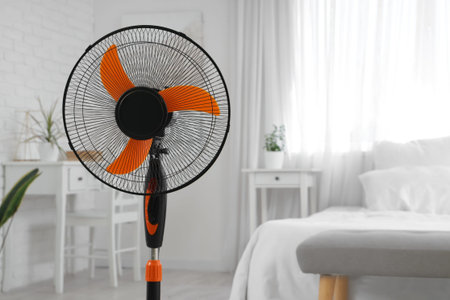 Electric fan on floor in bedroom
