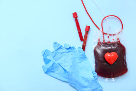Blood pack with heart, samples and gloves on blue background. World Blood Donor Dayの写真素材