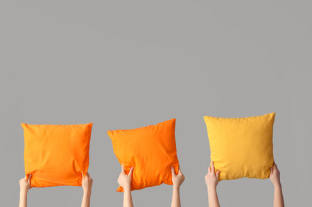 Women with bright pillows on gray backgroundの写真素材
