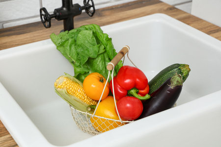 Basket with different fresh vegetables in sink, closeupの写真素材