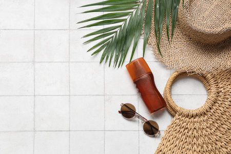Beautiful composition with beach accessories and sunscreen on tile backgroundの写真素材
