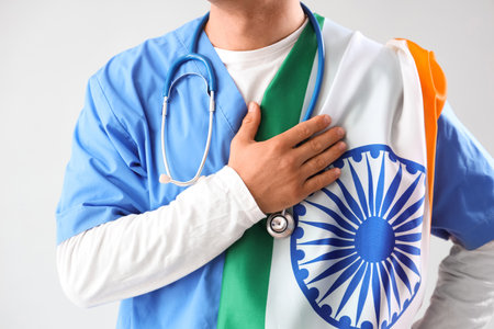 Male doctor with flag of India holding hand over heart on gray background, closeup. National Doctor's Day celebrationの写真素材