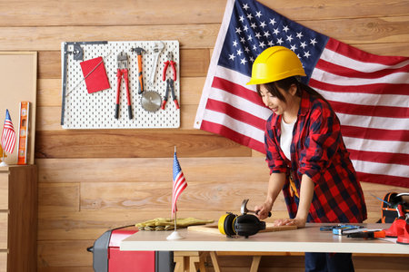 Female Asian worker hammering frame in workshop. Labor Day celebrationの写真素材