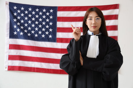 Female Asian judge against USA flag on light background. Labor Day celebrationの写真素材