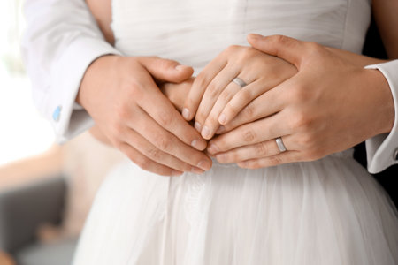 Young couple with rings hugging on their wedding day, closeupの写真素材