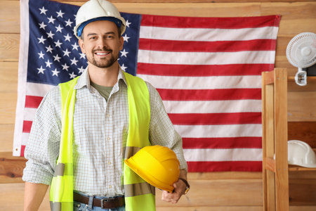 Male architect with hardhats against USA flag in workshop. Labor Day celebrationの写真素材