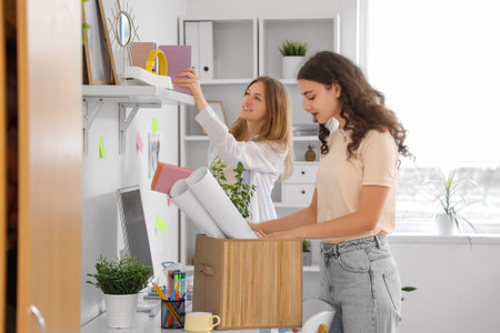 Female students unpacking things in dorm room on moving dayの写真素材