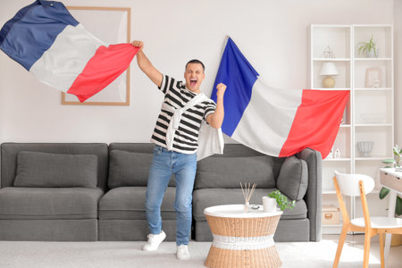 Happy young man with flags of France at homeの写真素材