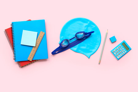 Composition with stationery, swimming cap and goggles on pink backgroundの写真素材