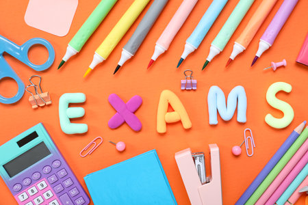 Composition with word EXAMS and colorful stationery on orange backgroundの写真素材