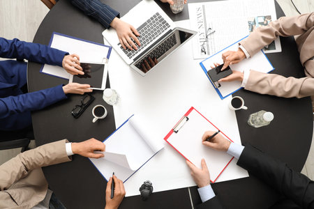 Business people with gadgets working at black table, top view