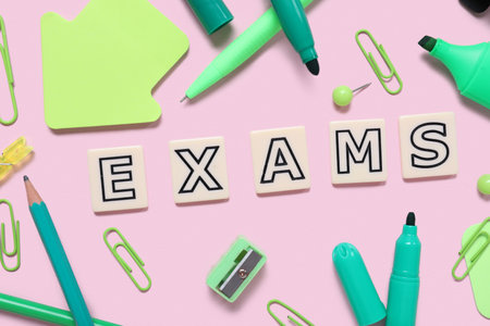 Composition with word EXAMS and different stationery on pink backgroundの写真素材
