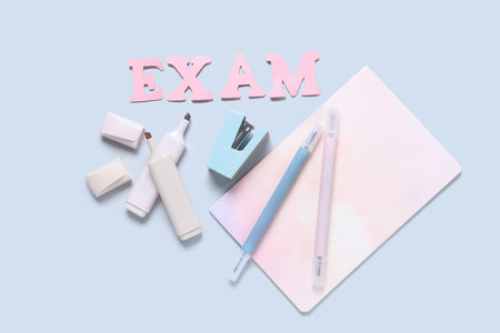 Composition with word EXAM and different stationery on gray backgroundの写真素材
