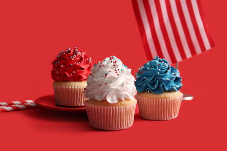 Tasty patriotic cupcakes with USA flag on red background. American Independence Dayの写真素材