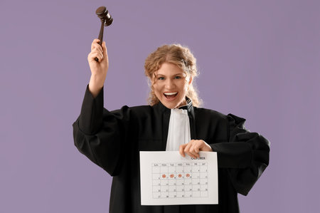 Female judge with gavel and menstrual calendar on violet backgroundの写真素材