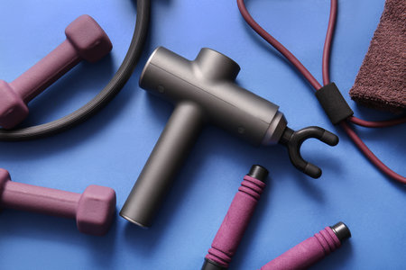 Composition with percussive massager and sports equipment on color backgroundの写真素材