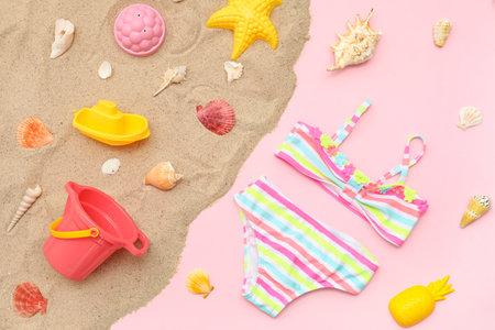 Beach accessories for children and kid's swimsuit on pink background. Top viewの写真素材