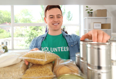 Male volunteer with food donations in center, closeupの写真素材