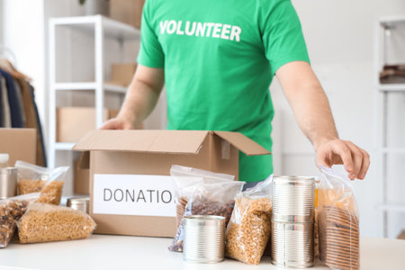 Male volunteer donating food in center, closeupの写真素材