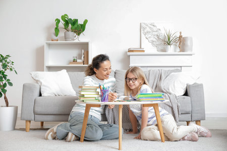 Little girl in eyeglasses studying with tutor at home