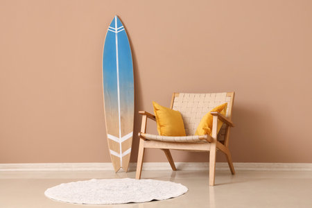 Surfboard and armchair near beige wall in living roomの写真素材