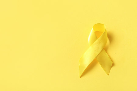 Yellow ribbon on color background. Sarcoma concept.の写真素材