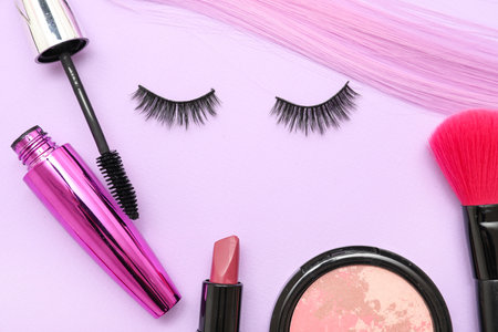 Composition with false eyelashes, hair strand and makeup accessories on lilac backgroundの写真素材