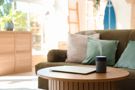 Air humidifier with laptop on table in living room, closeupの写真素材